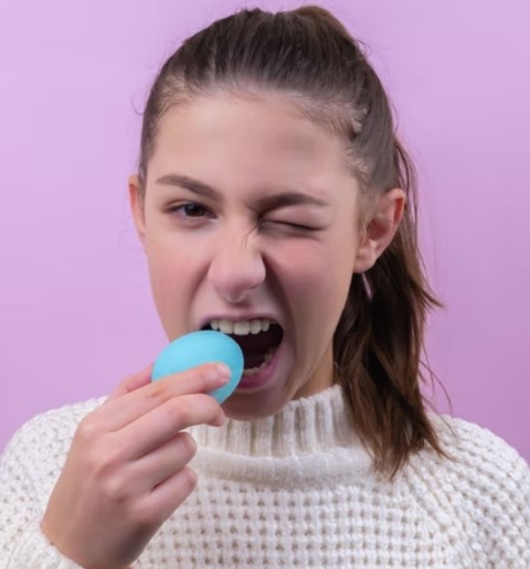 girl trying to eat blue egg